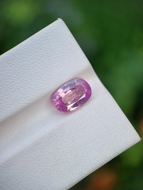 A photo of a pink sapphire from Afghanistan with oval mixed cut shape and transparent clarity on a white background | 2.62 ct | GGI certified