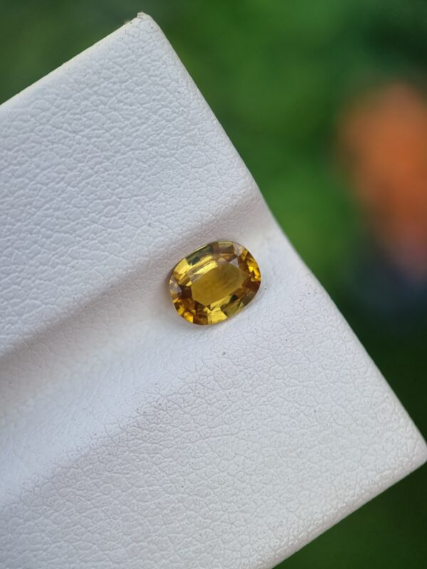 natural Epidote gemstone with a brownish-yellow color and oval shape