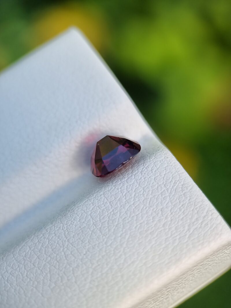 1.49 ct red cushion-cut Afghan Garnet, slightly included, reflecting natural sophistication.