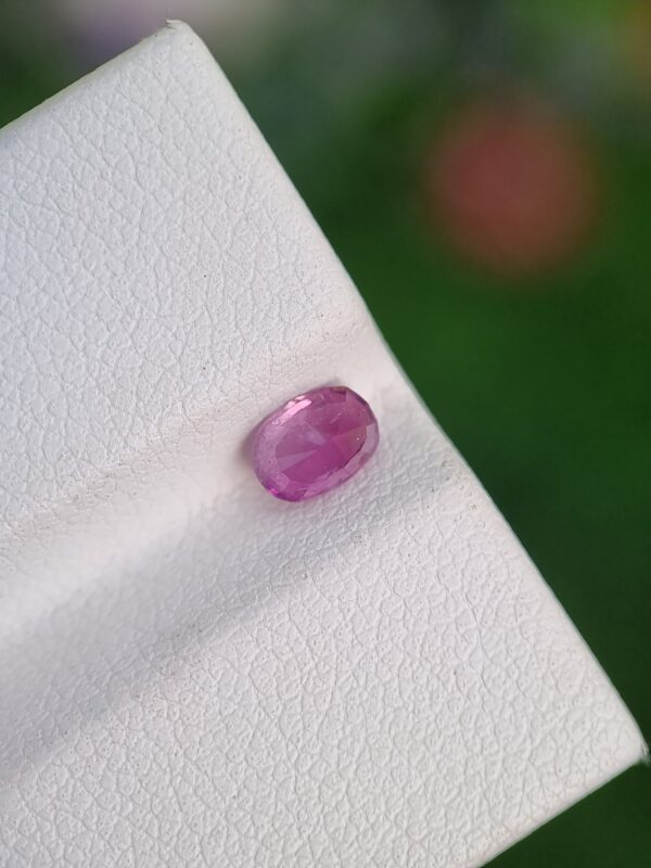 Captivating 0.60 ct oval natural sapphire, purplish pink, untreated, from Afghanistan’s rich gemstone mines.