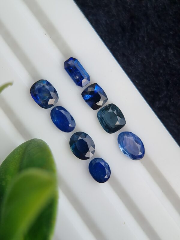 Collection of eight blue sapphires in various cuts and shades, certified by Galaxy Gemological Institute, perfect for fine jewelry.