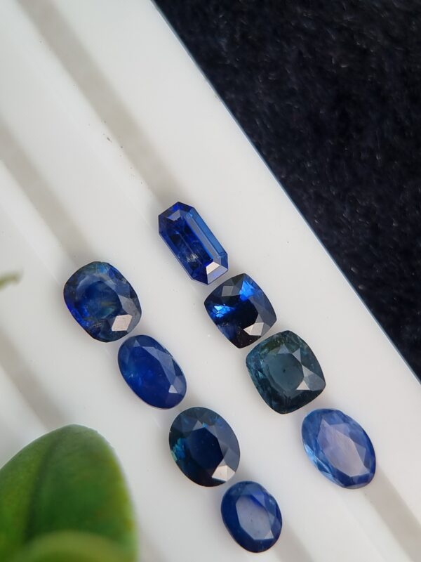 Collection of eight blue sapphires in various cuts and shades, certified by Galaxy Gemological Institute, perfect for fine jewelry.