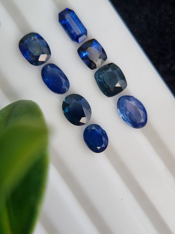 Collection of eight blue sapphires in various cuts and shades, certified by Galaxy Gemological Institute, perfect for fine jewelry.