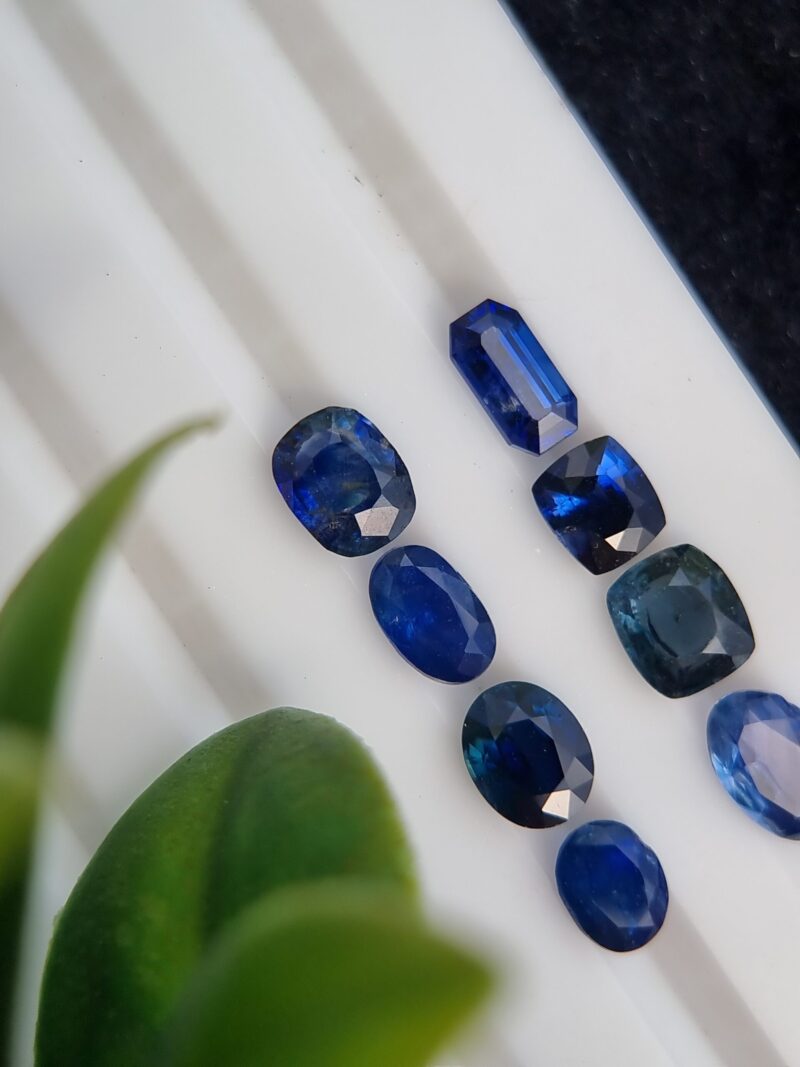 Collection of eight blue sapphires in various cuts and shades, certified by Galaxy Gemological Institute, perfect for fine jewelry.