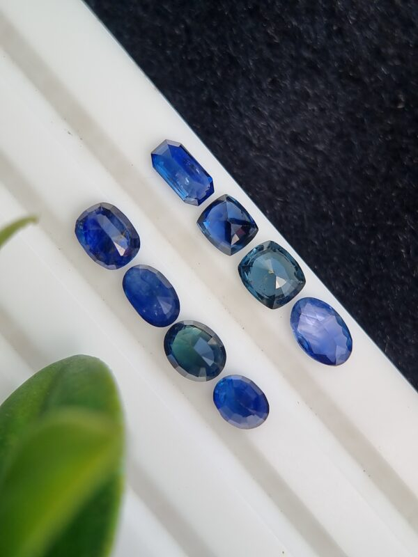Collection of eight blue sapphires in various cuts and shades, certified by Galaxy Gemological Institute, perfect for fine jewelry.