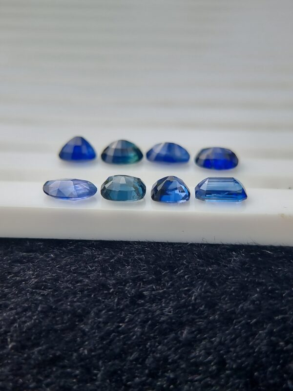 Collection of eight blue sapphires in various cuts and shades, certified by Galaxy Gemological Institute, perfect for fine jewelry.