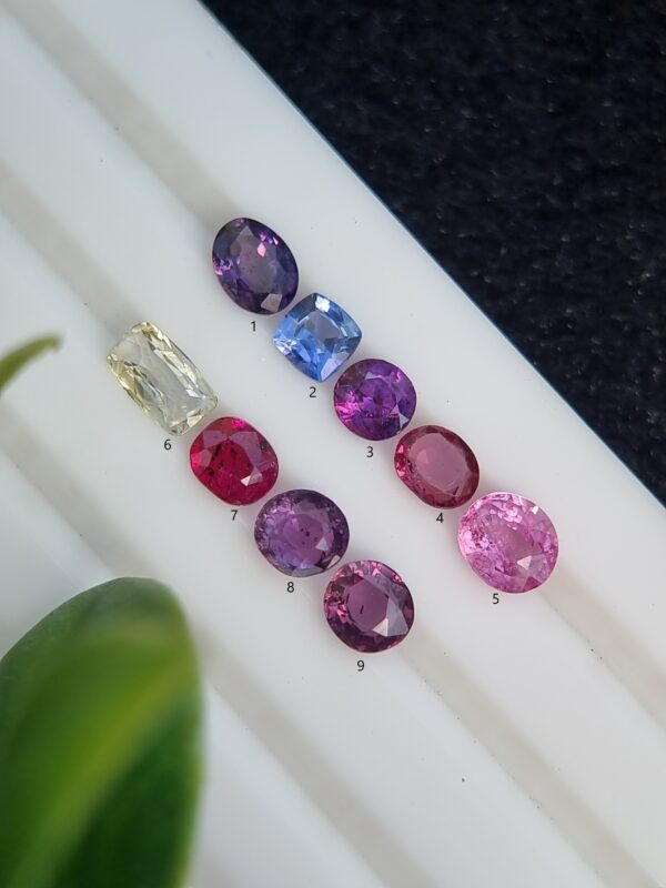 Assorted collection of nine certified natural sapphires in mixed cuts and a range of colors, totaling 5.09 carats.