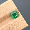 A professionally photographed 0.92 ct natural emerald with a classic emerald cut and pleasant green color. The image highlights the stone's transparency and natural inclusions.