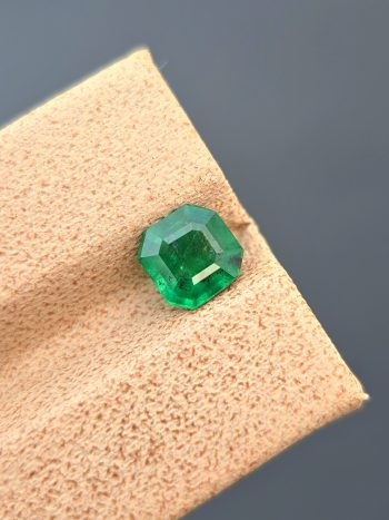 A professionally photographed 0.92 ct natural emerald with a classic emerald cut and pleasant green color. The image highlights the stone's transparency and natural inclusions.