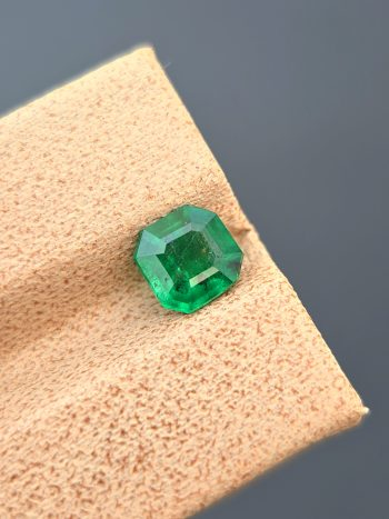 A professionally photographed 0.92 ct natural emerald with a classic emerald cut and pleasant green color. The image highlights the stone's transparency and natural inclusions.