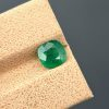 A high-quality image of a 1.09 carat natural cushion-cut green emerald with visible inclusions, photographed against a neutral background. The gemstone is from the Swat Valley in Pakistan.